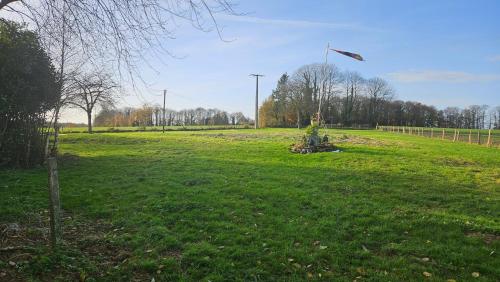 a grassy field with a kite flying in the sky at The Lions Den - La Loge Guest House in Mantilly