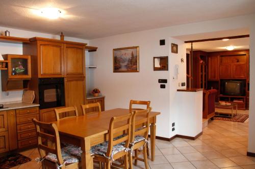 cocina y comedor con mesa de madera y sillas en Casa D'antan Gressan, en Aosta