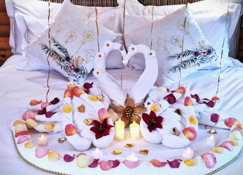 two white swans on a bed with candles at Tree Living in Krugersdorp