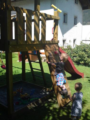 two young boys playing on a wooden playground at Appartements Schweiberer in Ried im Zillertal