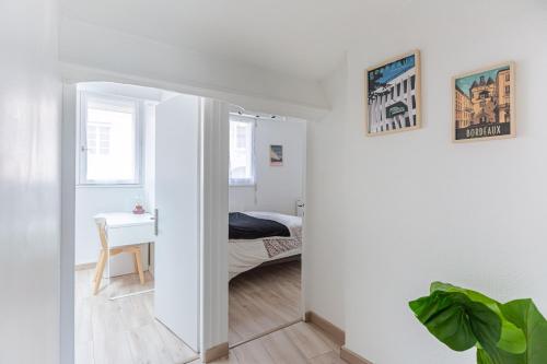Cette chambre blanche comprend un lit et un bureau. dans l'établissement Escapade Pey Berland, à Bordeaux