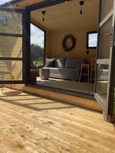 a living room with a couch on a deck at Tinyhouse Březina in Dolní Bezděkov