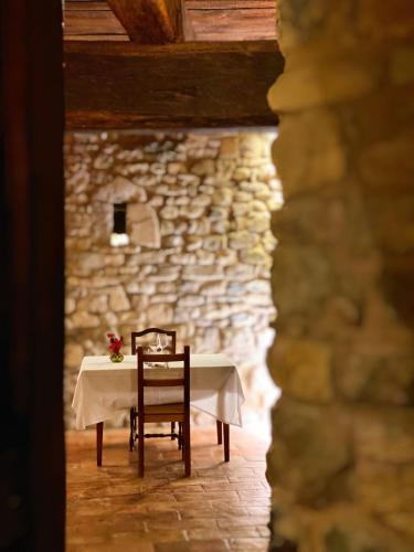 a table with two chairs and a stone wall at Castello di Viano in Viano