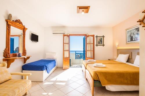 a hotel room with two beds and a couch at Arhontiko Hotel in Foinikion