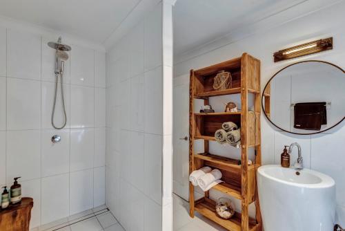 a bathroom with a shower and a sink and a mirror at Lumeah by the Creek in Whian Whian