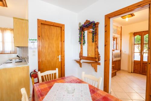 a dining room with a table and a kitchen at Arhontiko Hotel in Foinikion