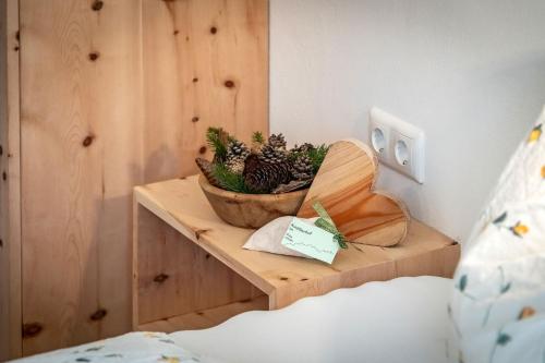 a wooden shelf with a bowl of plants on it at Austillerhof - Urlaub auf dem Bauernhof in Funes