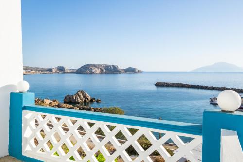 a blue and white fence with a view of the ocean at Arhontiko Hotel in Foinikion