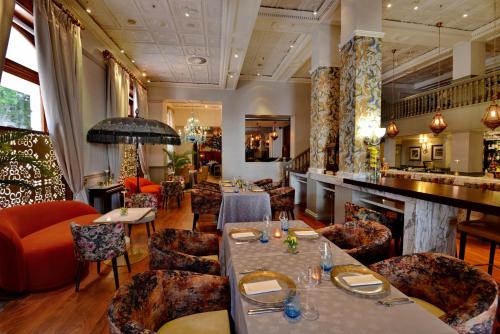 a restaurant with tables and chairs and a bar at Taj Cape Town in Cape Town