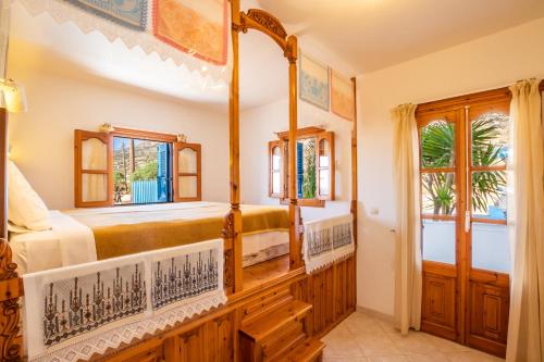 a bedroom with a four poster bed and a window at Arhontiko Hotel in Foinikion