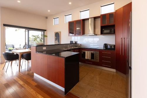 a kitchen with wooden cabinets and a black counter top at Pleasant View Stays TORQUAY in Torquay