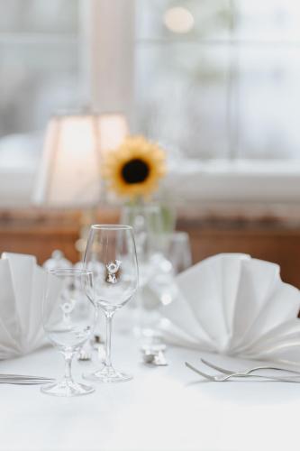 a table with two wine glasses and white napkins at Romantik Hotel zur Post in Fürstenfeldbruck