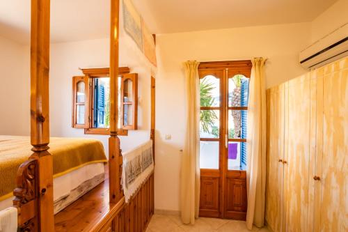 a bedroom with a bed and a window at Arhontiko Hotel in Foinikion