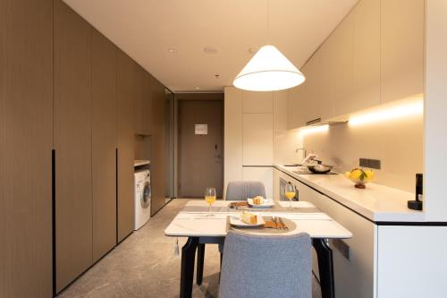 a kitchen and dining room with a table and chairs at Ascott Fengyishan Shenzhen in Shenzhen