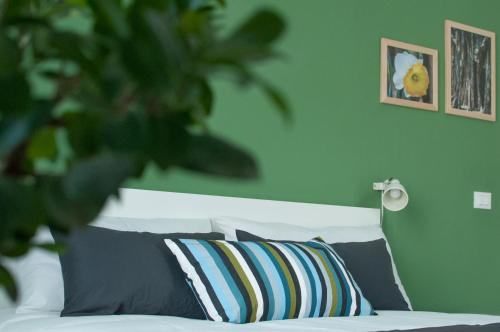 a green bedroom with a bed with a striped pillow at B&B Dietro il Teatro in Palermo