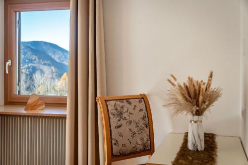 a table and a chair with a vase of flowers at Austillerhof - Urlaub auf dem Bauernhof in Funes