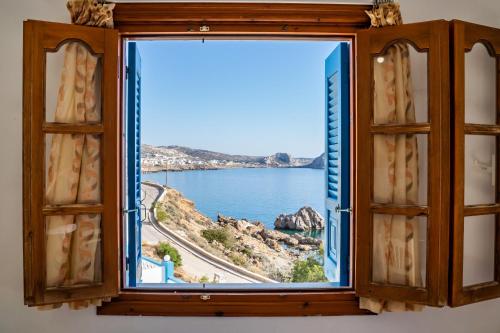 an open window with a view of the ocean at Arhontiko Hotel in Foinikion