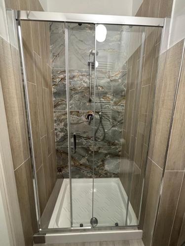 bagno con doccia e parete in pietra di DOMUS Hotel a Caselle Torinese