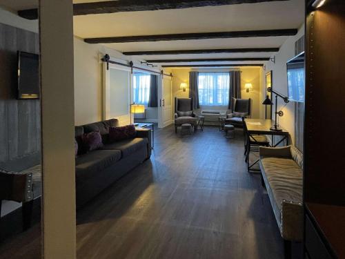 a living room with a couch and chairs and a table at The Century House, an Ascend Collection Hotel in Latham