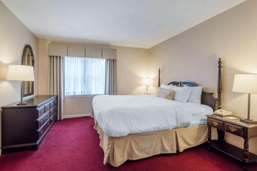 a hotel room with a large bed and two lamps at The Century House, an Ascend Collection Hotel in Latham