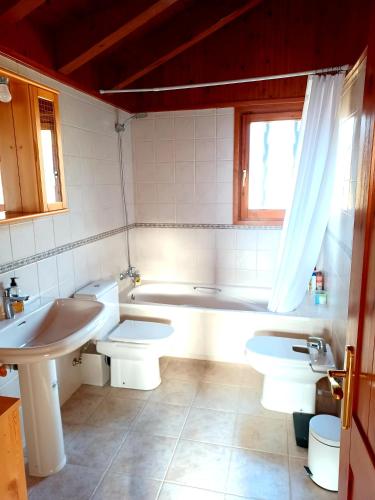 une salle de bain avec deux toilettes, une baignoire et un lavabo dans l'établissement Maison Bellevue, à Osséja