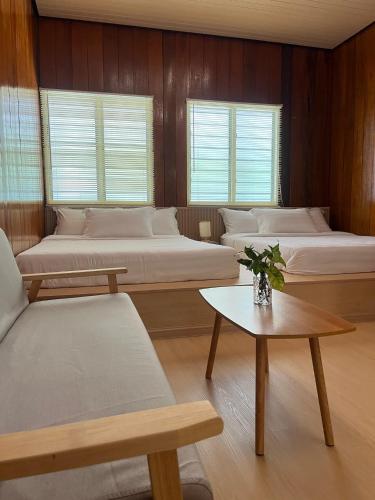 a room with four beds and a table and chairs at Manson Goat Cottage in Cameron Highlands