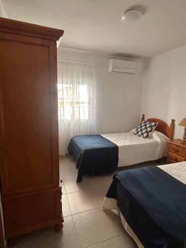 a bedroom with two beds and a dresser at Casa Carmen in Candeleda