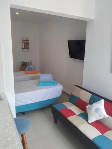 a small room with two beds and a couch at Yumbo Rainbow Homes C in Maspalomas