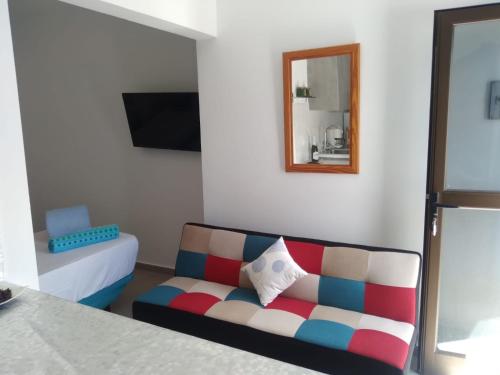 een woonkamer met een bank en een spiegel bij Yumbo Rainbow Homes C in Maspalomas