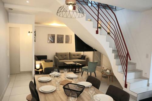 ein Esszimmer mit einem Tisch und einer Treppe in der Unterkunft Maison La Belfort You proche TechnHom in Belfort