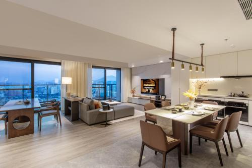 a kitchen and living room with a dining room and a living room at Ascott Fengyishan Shenzhen in Shenzhen