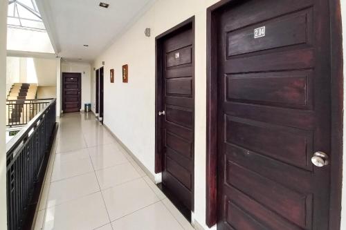a hallway with a black door and a hallwayngth at D Cost 19 Syariah Mitra RedDoorz in Palas 2