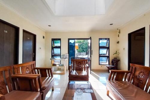 a living room with chairs and a table and windows at D Cost 19 Syariah Mitra RedDoorz in Palas 2