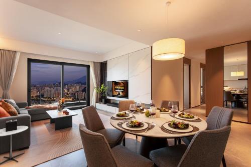 a dining room and living room with a table and chairs at Ascott Fengyishan Shenzhen in Shenzhen