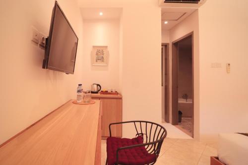 a living room with a chair and a flat screen tv at Amaya Residence Jimbaran in Jimbaran