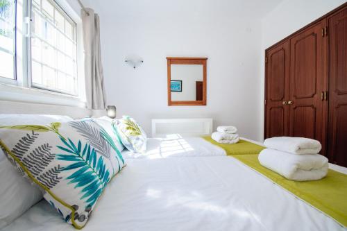 a bedroom with a large bed with towels on it at Casa Filipa Lower Floor - Charming 3-Bedroom Villa with Heated Pool in Praia do Carvoeiro