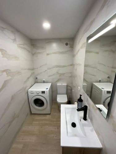 a bathroom with a toilet and a sink and a mirror at AwayDays Apartamento en la 4a planta vista mar in Empuriabrava