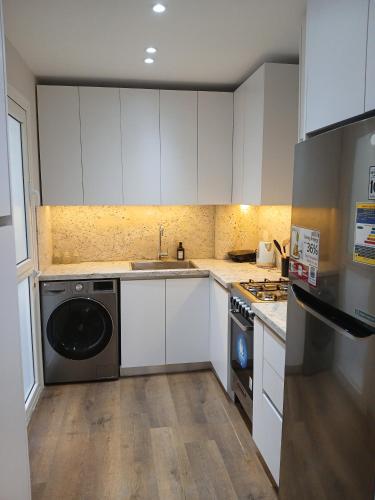 a kitchen with white cabinets and a black dishwasher at Dar Residence - Madinaty B12 - U2 - 2 BR - New Cairo in Madinaty