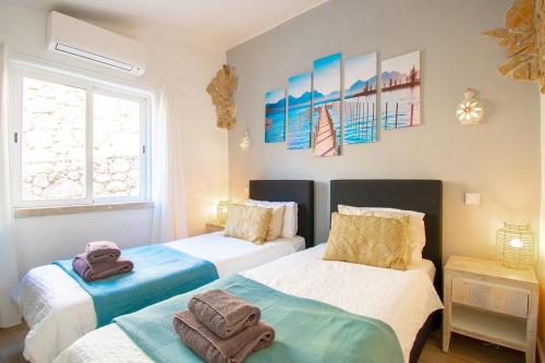 ein Schlafzimmer mit zwei Betten mit Handtüchern darauf in der Unterkunft C65 Quinta do Paraiso - Charming 2-Bedroom Bungalow in Carvoeiro