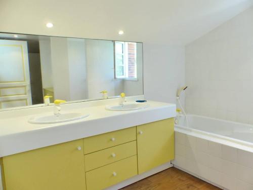 une salle de bain avec deux lavabos et un grand miroir dans l'établissement Villa les chardonnerets entre Lac et Océan pour 10-12 personnes, à Hossegor