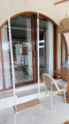 a swing in a room with a chair and a table at Cape Beach Villa Samui in Ban Bang Po