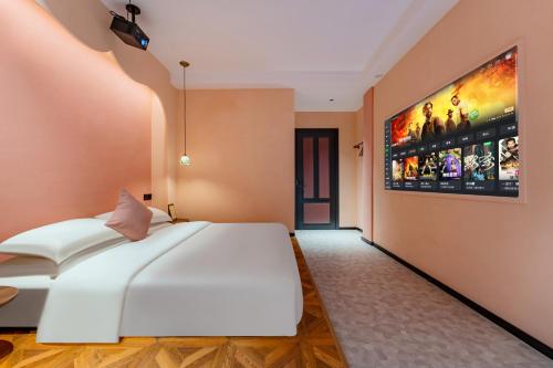 a bedroom with a large white bed and a painting on the wall at Chaozhou Fanhuali B&B in Chaozhou
