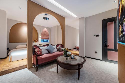 a hotel room with a bed and a couch and a table at Chaozhou Fanhuali B&B in Chaozhou