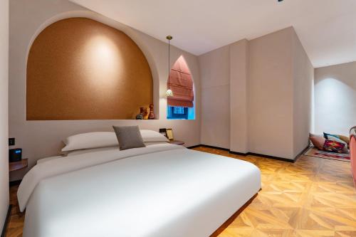a bedroom with a large white bed with an arch overhead at Chaozhou Fanhuali B&B in Chaozhou