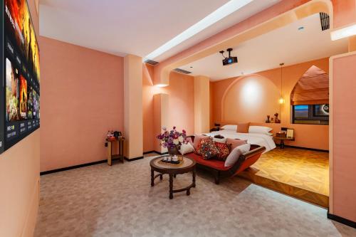 a hotel room with a bed and a couch at Chaozhou Fanhuali B&B in Chaozhou