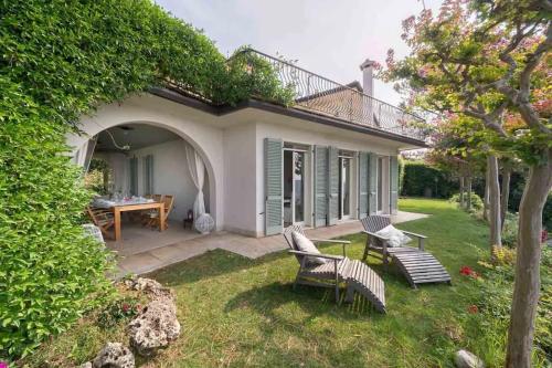 a garden with chairs and a table in a yard at Villa Rosa del Garda Golf and Bike in Garda