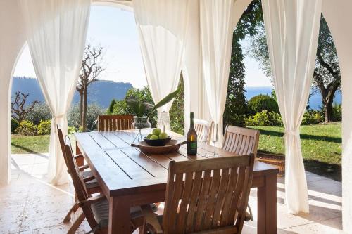 a wooden table with chairs and a bottle of wine at Villa Rosa del Garda Golf and Bike in Garda