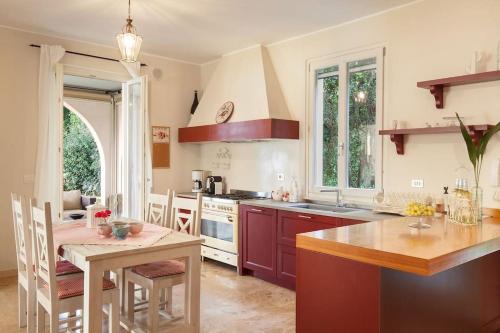 a kitchen with a table and a dining room at Villa Rosa del Garda Golf and Bike in Garda