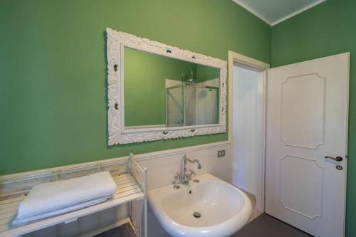 a green bathroom with a sink and a mirror at Villa Rosa del Garda Golf and Bike in Garda