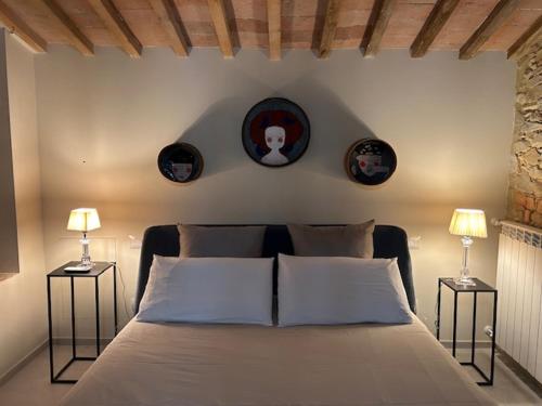 a bedroom with a bed and two pictures on the wall at Morelliana4Rooms in Scansano